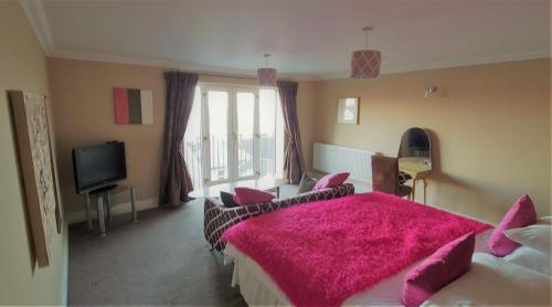 a bedroom with two beds with a pink blanket at Patricks Boathouse in Swansea