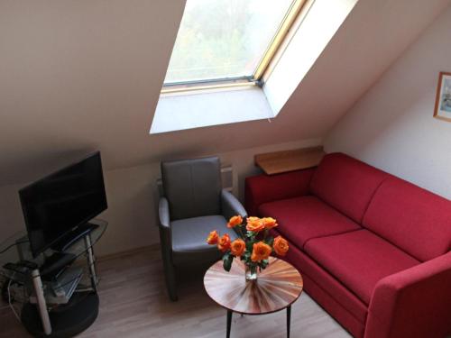 a living room with a red couch and a window at Apartment Gollwitzer Park - Insel Poel-6 by Interhome in Gollwitz