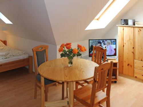 uma sala de jantar com mesa e cadeiras e uma televisão em Apartment Gollwitzer Park - Insel Poel-5 by Interhome em Gollwitz