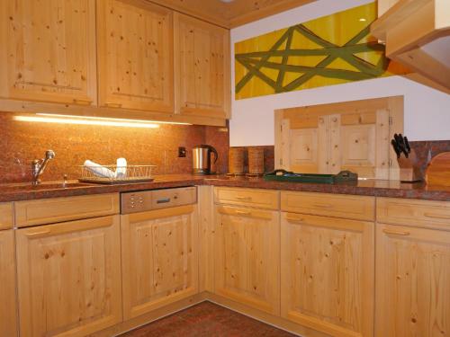una cucina con armadi in legno e lavandino di Apartment Chesa Dal Luf B6 by Interhome a Silvaplana