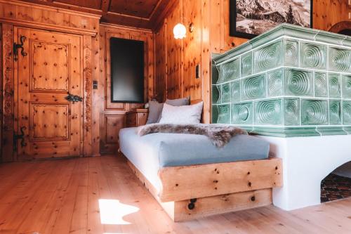 Schlafzimmer mit einem Bett mit einem Kopfteil aus grünem Glas in der Unterkunft Alpenherz Chalet in Elbigenalp