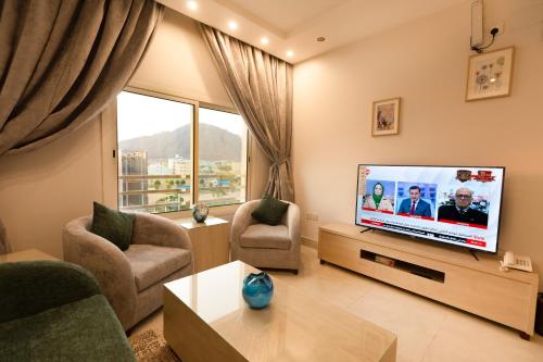 a living room with a flat screen tv at أحلى الأيام للوحدات الفندقية-محايل عسير in Muhayil
