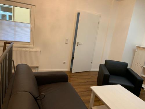 - un salon avec un canapé et une chaise dans l'établissement Apartments SMAG Barbiergasse, à Pirna