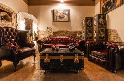 a living room with leather furniture and a trunk at Palazzo Barbini Dimora Storica in Castiglione del Lago