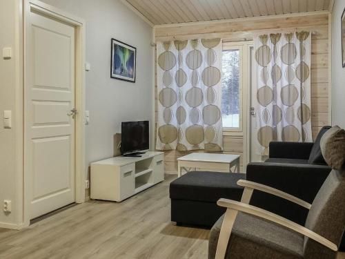 ein Wohnzimmer mit Sofa und Fernseher in der Unterkunft Holiday Home Levin revontulitaivas d by Interhome in Köngäs