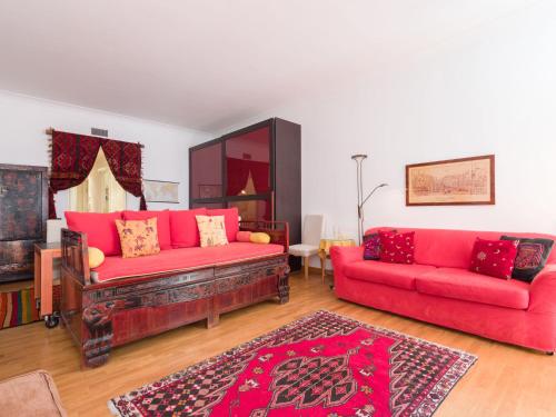 a living room with two red couches and a rug at Apartment Regina Ottavia by Interhome in Rome