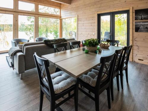 a living room with a wooden table and chairs at Holiday Home Villa kurki by Interhome in Torvoila