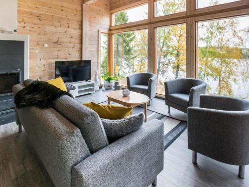 a living room with a couch and two chairs and a television at Holiday Home Villa kurki by Interhome in Torvoila