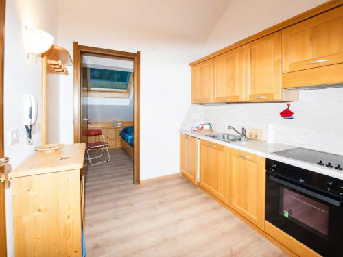 a kitchen with wooden cabinets and a sink at Apartment Enrosadira-7 by Interhome in Alba di Canazei