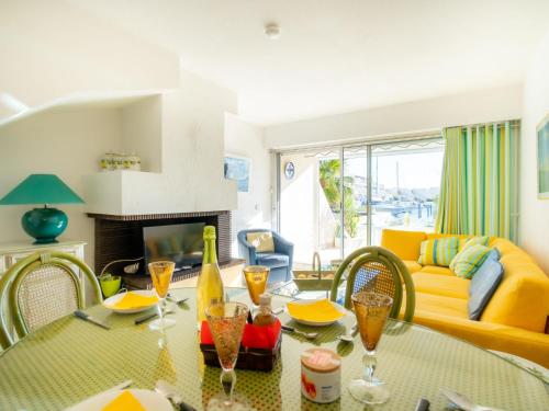 a living room with a table and a yellow couch at Holiday Home Hélios by Interhome in Le Grau-du-Roi