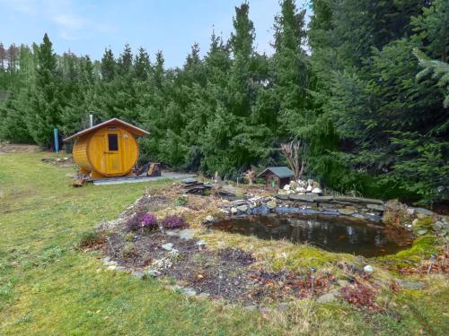 une petite maison dans un champ avec un étang dans l'établissement Holiday Home Panoramablick by Interhome, à Piesau