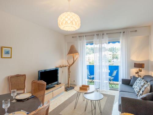 a living room with a blue couch and a tv at Apartment L'Amiral-1 by Interhome in Cagnes-sur-Mer