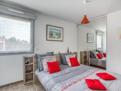 une chambre avec un grand lit avec des oreillers rouges dans l'établissement Apartment Le Jardin du Loderi-1 by Interhome, à Bormes-les-Mimosas