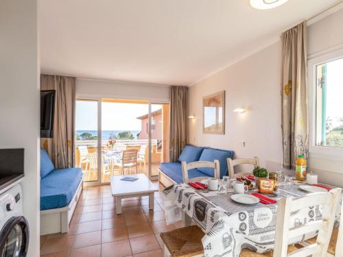 un salon avec un canapé bleu et une table dans l'établissement Apartment Les Rivages des Issambres-6 by Interhome, aux Issambres