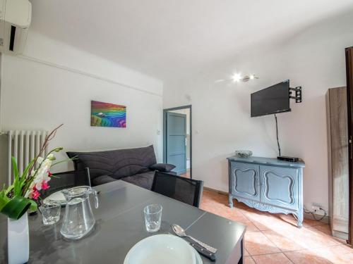 uma sala de estar com uma mesa e um sofá em Apartment Le Narcisse by Interhome em Cagnes-sur-Mer