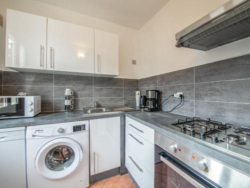 a kitchen with a washer and a sink and a washing machine at Apartment Le Narcisse by Interhome in Cagnes-sur-Mer
