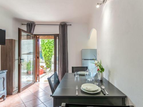 une salle à manger avec une table et une cuisine avec une porte dans l'établissement Apartment Le Narcisse by Interhome, à Cagnes-sur-Mer