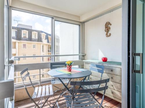 einen kleinen Tisch und Stühle auf einem Balkon mit Fenster in der Unterkunft Studio Victoria Surf-11 by Interhome in Biarritz