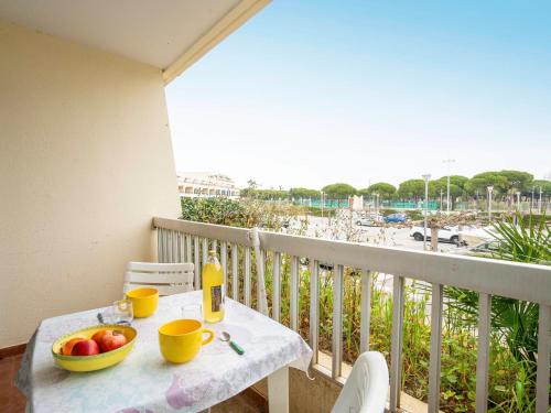 een tafel met een fruitschaal op een balkon met uitzicht op het strand bij Studio Le Grand Pavois-4 by Interhome in Le Grau-du-Roi