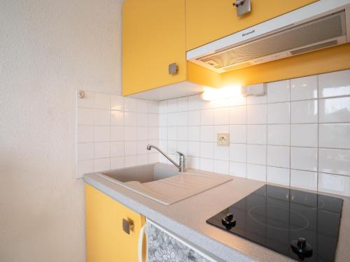 a kitchen with yellow cabinets and a sink at Studio Le Grand Pavois-4 by Interhome in Le Grau-du-Roi