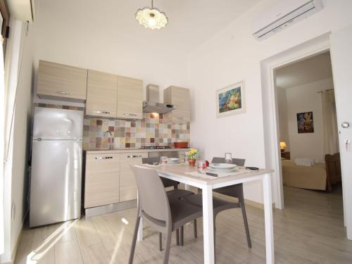 una cucina con tavolo, sedie e frigorifero di Apartment Ginestra SinAgo by Interhome a Lascari
