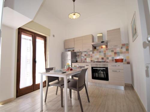 una cucina con tavolo e sedie in una stanza di Apartment Ginestra SinAgo by Interhome a Lascari