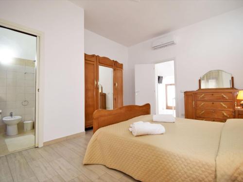 a white bedroom with a bed and a bathroom at Apartment Ginestra SinAgo by Interhome in Lascari