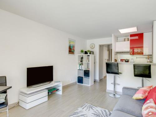 a living room with a couch and a flat screen tv at Studio Le Mexico-8 by Interhome in Saint-Raphaël