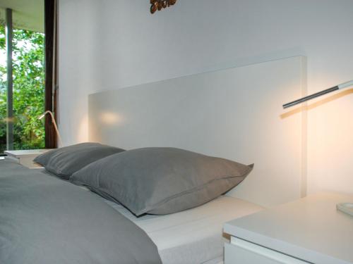 a bed with gray pillows on it in a bedroom at Apartment App- Castausio 26 by Interhome in Lugano