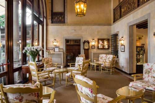アーゾロにあるホテル ヴィラ チプリアーニの椅子とテーブルと花が飾られた待合室