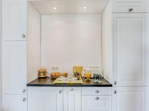 une cuisine avec des armoires blanches et un comptoir noir dans l'établissement Apartment Carlton-2 by Interhome, à Biarritz