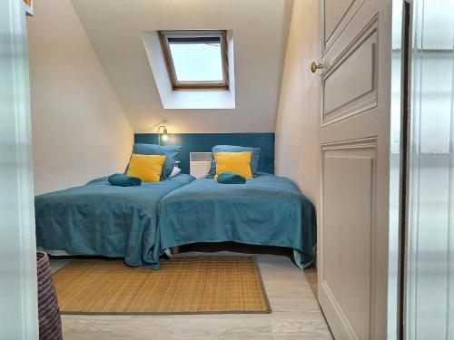 - une chambre avec un lit doté de draps bleus et d'oreillers jaunes dans l'établissement Maison Chic & charme Calme avec Jardin, au Mans