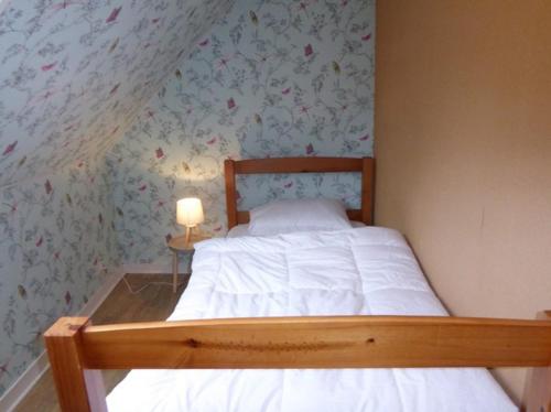 a bedroom with a bed with a flowery wall at penty breton in Pouldreuzic