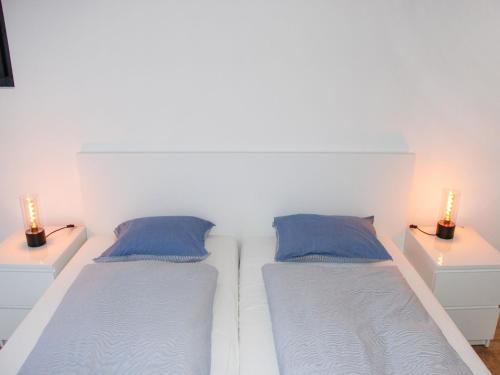 two beds in a white room with two lamps at Apartment Fiorita by Interhome in Brusino Arsizio