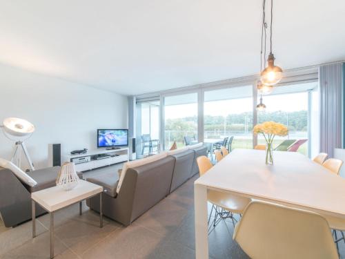 ein Wohnzimmer mit einem Tisch und Stühlen sowie einem TV in der Unterkunft Apartment Residentie Odyssea I by Interhome in Bredene