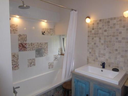 a bathroom with a tub and a sink and a shower at penty breton in Pouldreuzic