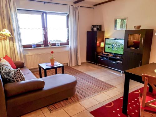 a living room with a couch and a tv at Holiday Home Ferienpark Himmelberg-5 by Interhome in Thalfang