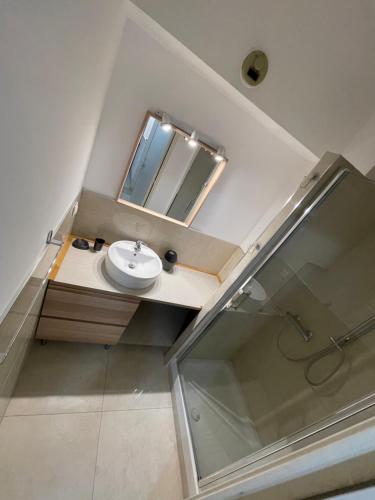une salle de bain avec un lavabo et un miroir dans l'établissement Appartements Villa Rimbaud by Connexion, à Cannes