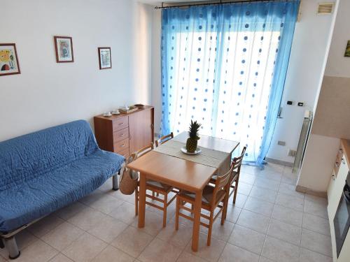 a living room with a table and a blue couch at Apartment Adriatico-2 by Interhome in San Silvestro