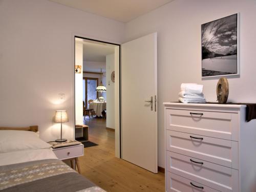 1 dormitorio con 1 cama y vestidor con espejo en Apartment Chesa Ginellas by Interhome, en Sils-Maria