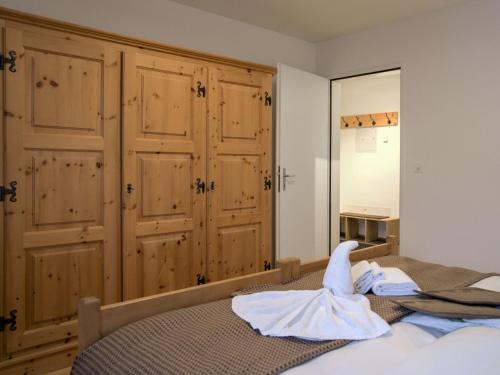 a bedroom with a bed with wooden cabinets at Apartment Chesa Ginellas by Interhome in Sils Maria