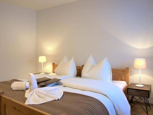 a bedroom with a large bed with white sheets and pillows at Apartment Chesa Ginellas by Interhome in Sils Maria