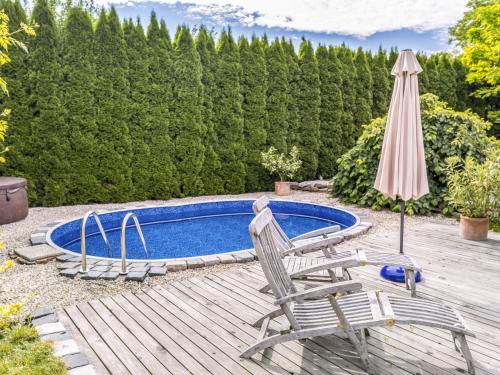 a swimming pool with two chairs and an umbrella at Apartment Zábřeh-Lukavice 1 by Interhome in Zábřeh