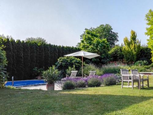 a garden with two chairs and an umbrella next to a pool at Apartment Zábřeh-Lukavice 1 by Interhome in Zábřeh
