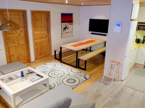 een woonkamer met een tafel en een televisie bij Holiday Home Saariseläntie 8 e 11 by Interhome in Saariselkä
