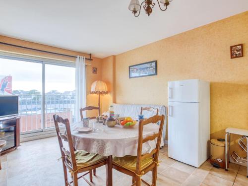 cocina con mesa y nevera blanca en Apartment Résidence Les Béniguets by Interhome, en Quiberon
