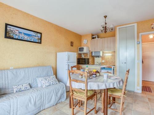 cocina y sala de estar con mesa y sofá. en Apartment Résidence Les Béniguets by Interhome, en Quiberon