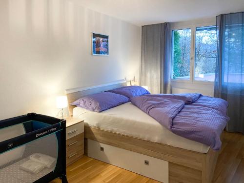 una camera da letto con un letto con cuscini viola e una finestra di Apartment Bella Vista by Interhome a Magadino