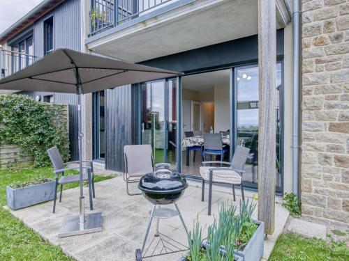 - une terrasse avec un barbecue, des chaises et un parasol dans l'établissement Apartment Les Hauts de Port Mer by Interhome, à Cancale