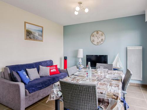un salon avec une table et un canapé bleu dans l'établissement Apartment Les Hauts de Port Mer by Interhome, à Cancale